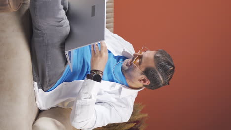 Vertical-video-of-Man-looking-at-laptop-in-amazement.